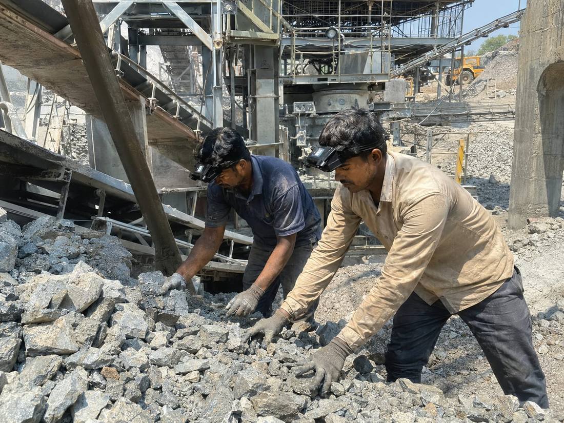 Workers at a stone crushing site wearing head-mounted cameras